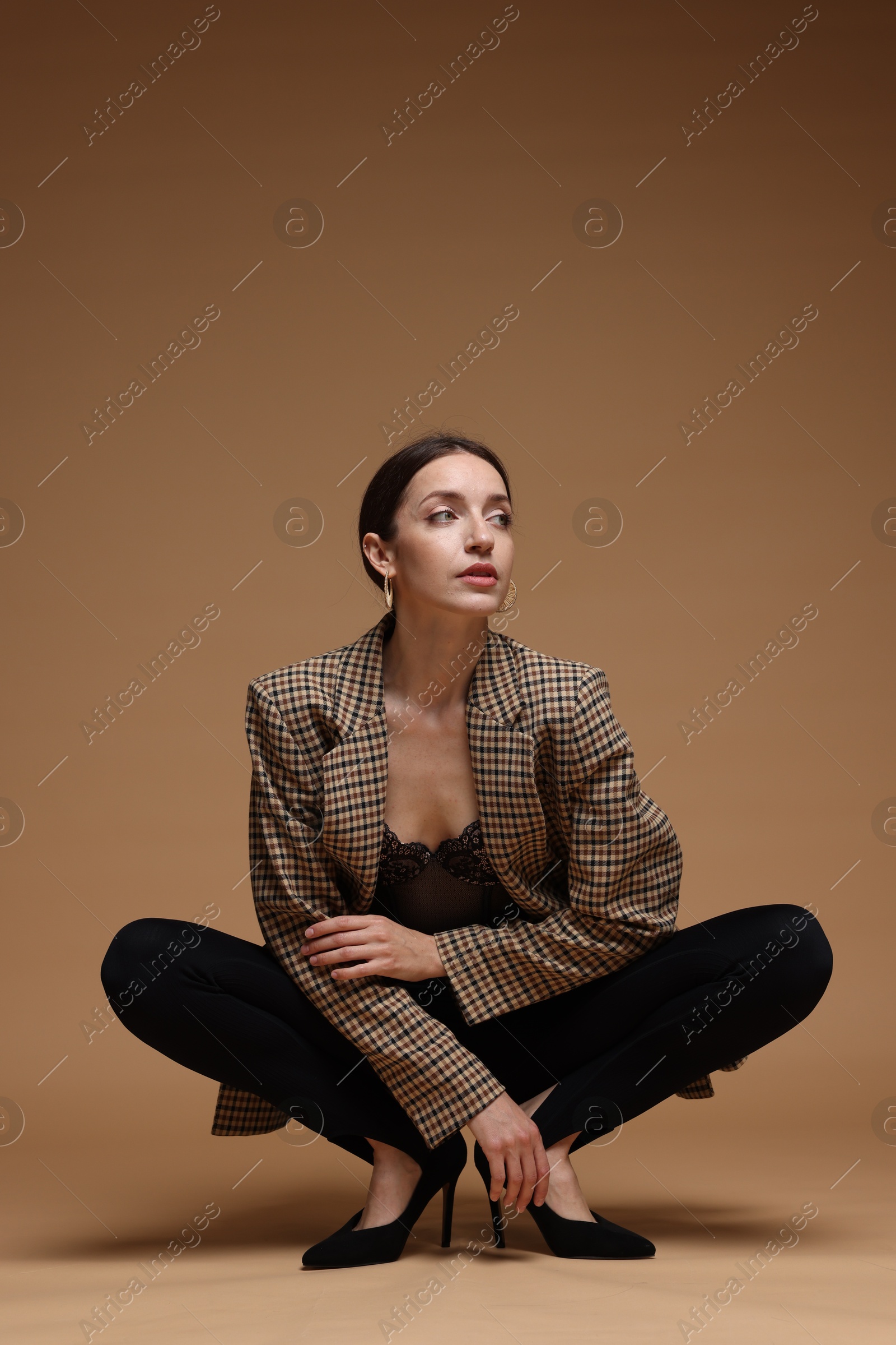 Full-length portrait of beautiful woman in stylish outfit on beige background Photo of Full-length portrait of beautiful woman in stylish outfit on beige background