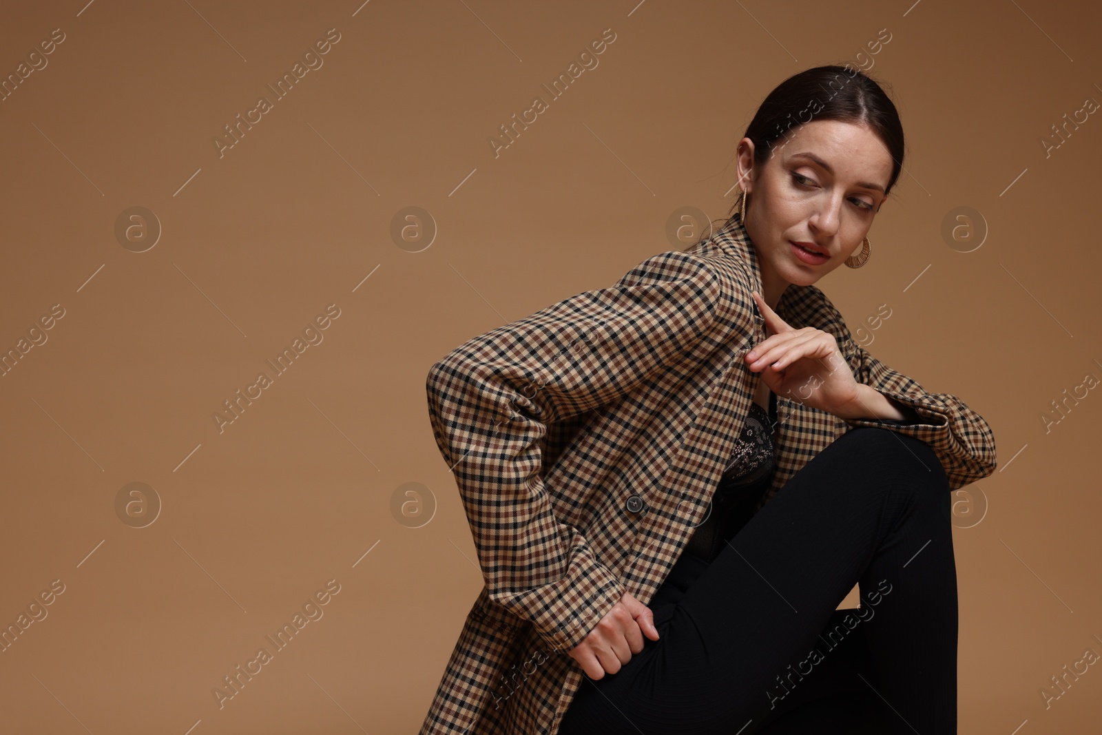 Portrait of beautiful woman in stylish outfit on beige background, space for text Photo of Portrait of beautiful woman in stylish outfit on beige background, space for text