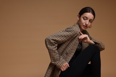 Photo of Portrait of beautiful woman in stylish outfit on beige background, space for text