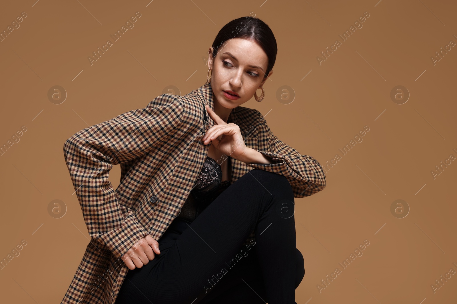 Portrait of beautiful woman in stylish outfit on beige background Photo of Portrait of beautiful woman in stylish outfit on beige background