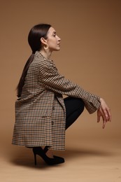 Photo of Full-length portrait of beautiful woman in stylish outfit on beige background
