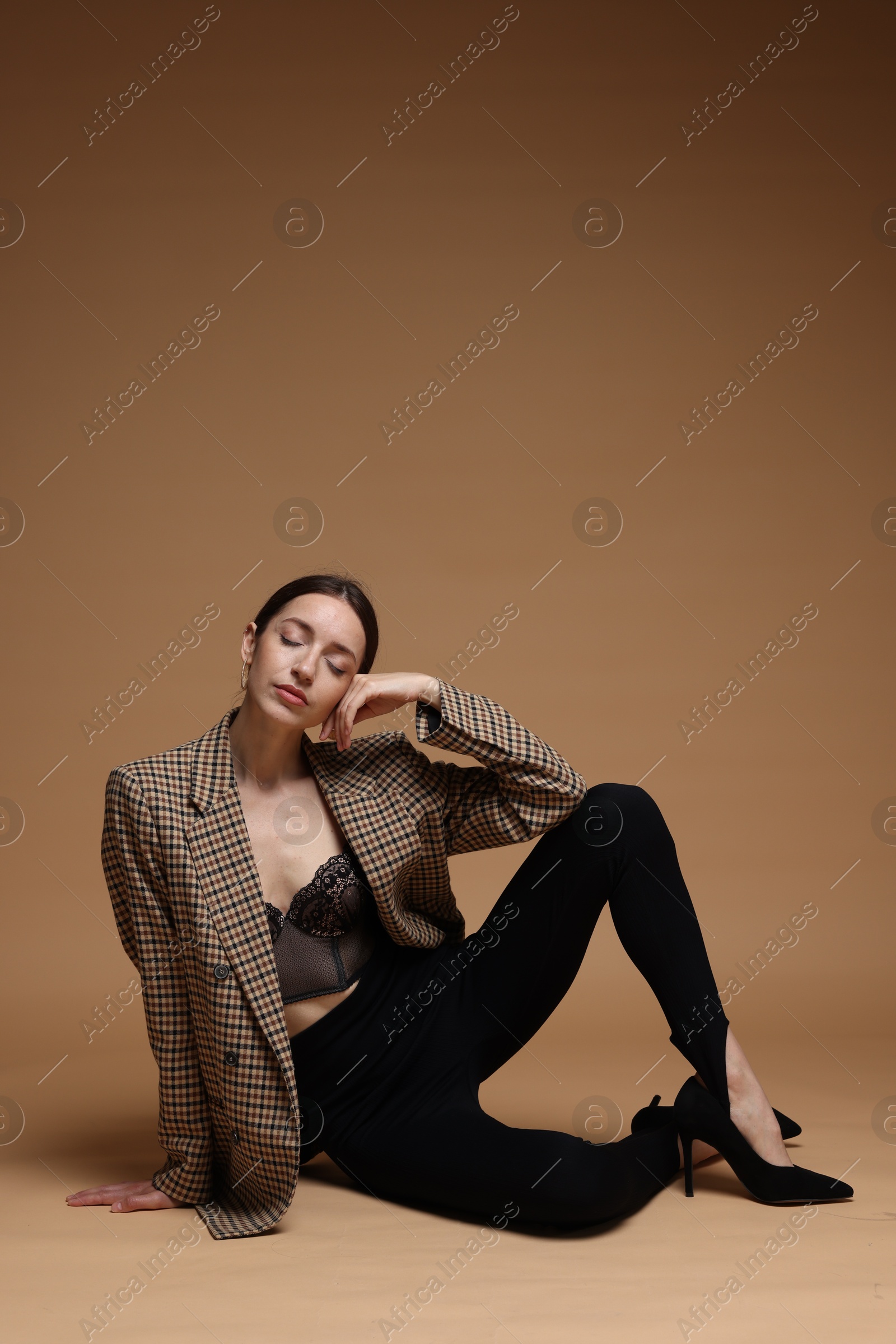 Full-length portrait of beautiful woman in stylish outfit on beige background, space for text Photo of Full-length portrait of beautiful woman in stylish outfit on beige background, space for text
