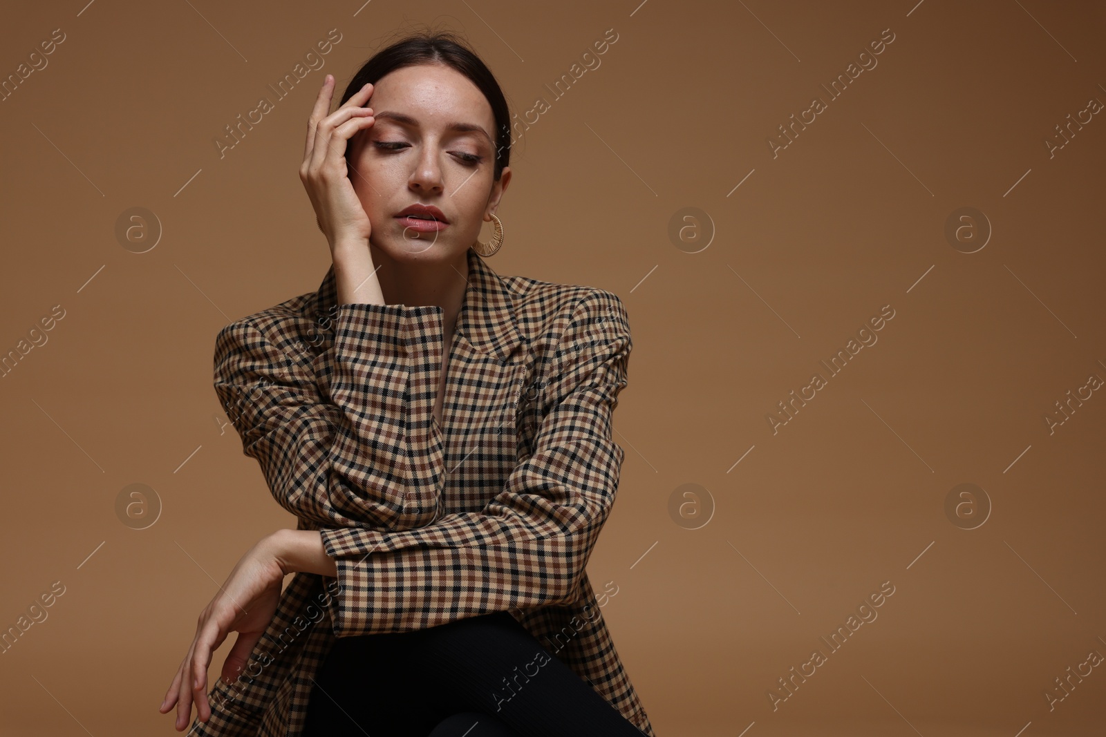 Portrait of beautiful woman in stylish outfit on beige background, space for text Photo of Portrait of beautiful woman in stylish outfit on beige background, space for text