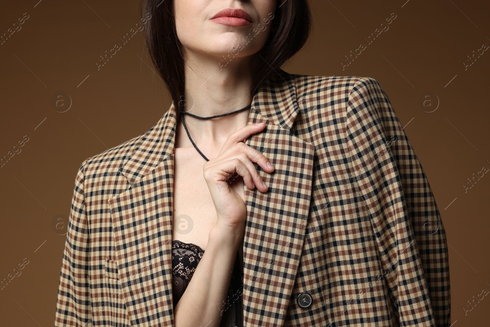 Beautiful woman in stylish outfit on brown background, closeup Photo of Beautiful woman in stylish outfit on brown background, closeup
