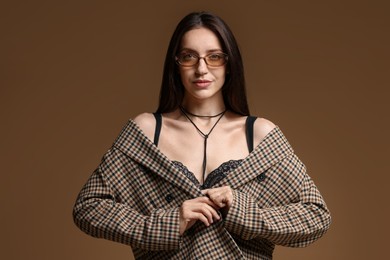Photo of Portrait of beautiful woman in stylish outfit on brown background