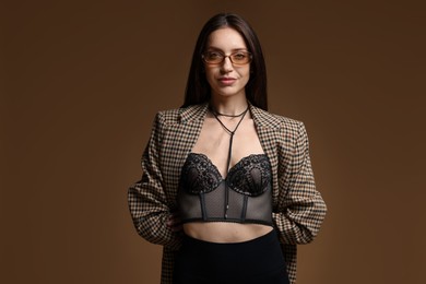 Photo of Portrait of beautiful woman in stylish outfit on brown background