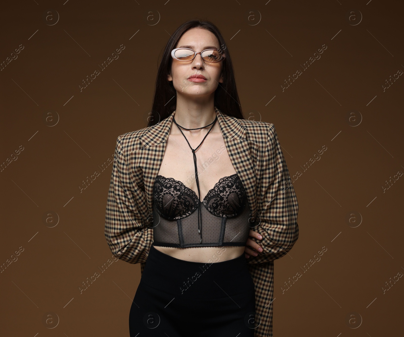 Portrait of beautiful woman in stylish outfit on brown background Photo of Portrait of beautiful woman in stylish outfit on brown background