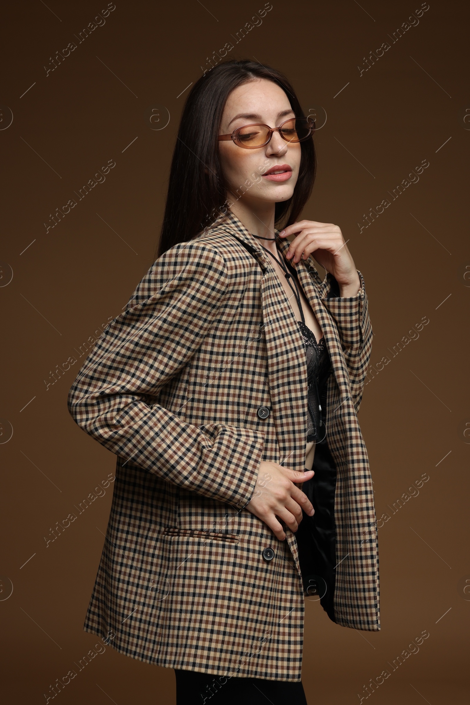 Portrait of beautiful woman in stylish outfit on brown background Photo of Portrait of beautiful woman in stylish outfit on brown background