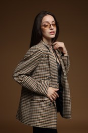 Photo of Portrait of beautiful woman in stylish outfit on brown background