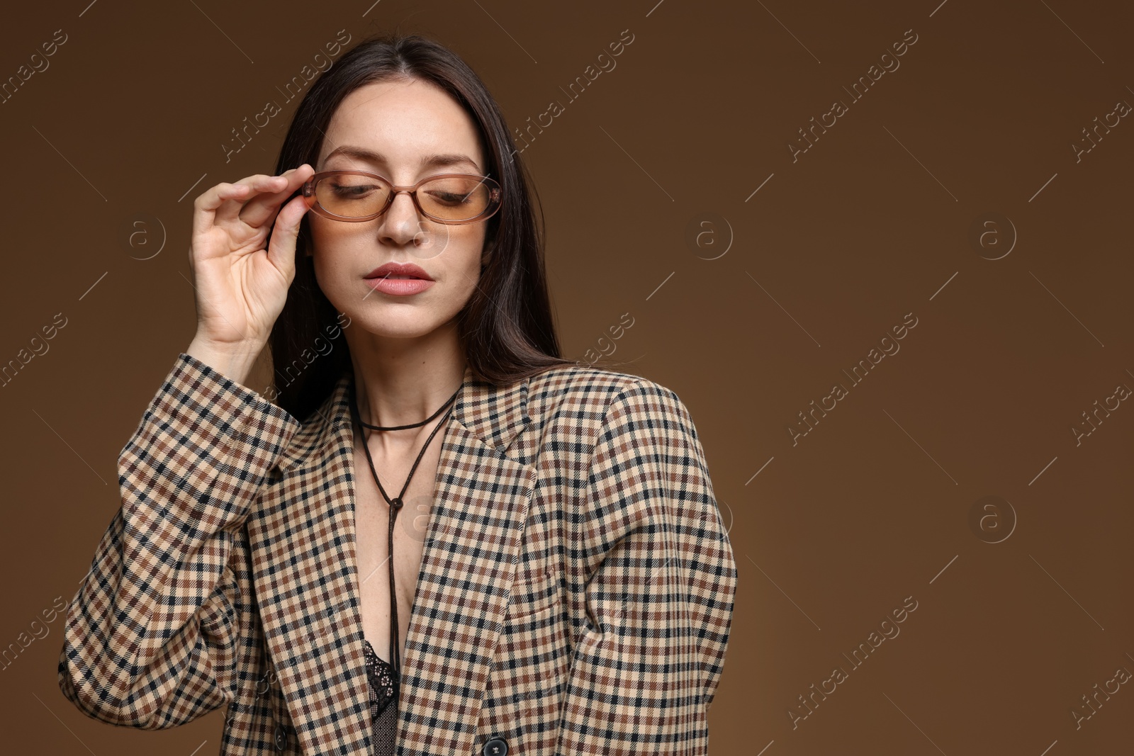 Portrait of beautiful woman in stylish outfit on brown background, space for text Photo of Portrait of beautiful woman in stylish outfit on brown background, space for text