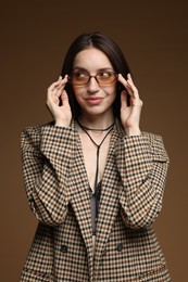 Photo of Portrait of beautiful woman in stylish outfit on brown background