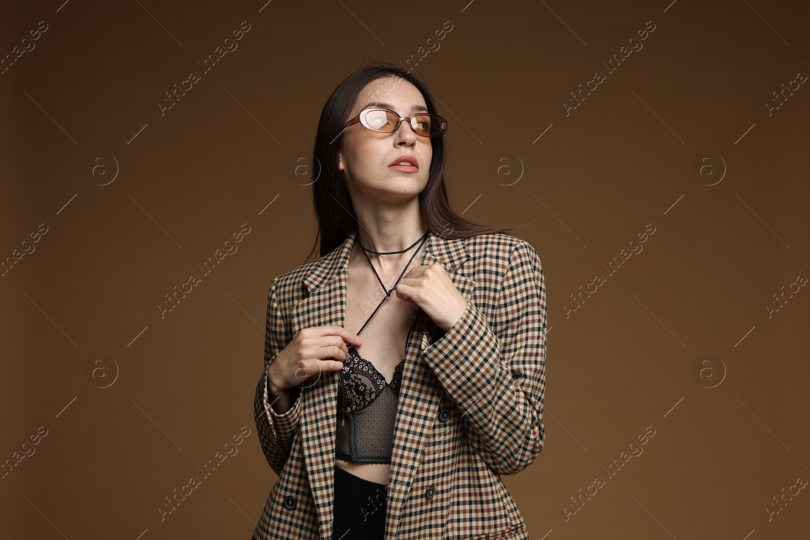 Portrait of beautiful woman in stylish outfit on brown background Photo of Portrait of beautiful woman in stylish outfit on brown background