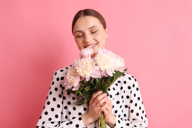 Photo of Woman with beautiful bouquet of peonies on pink background