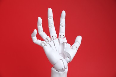 Photo of One white mannequin hand on red background