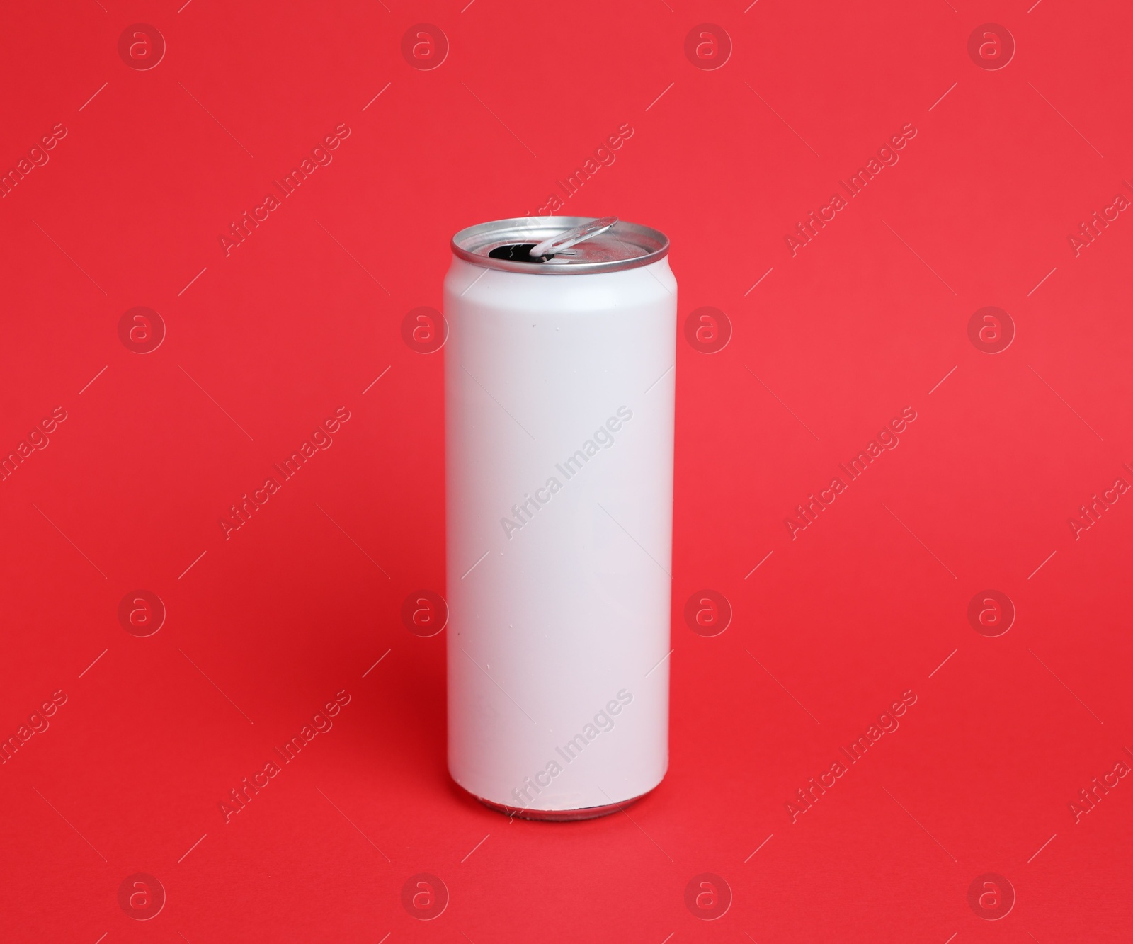One white tin can on red background Photo of One white tin can on red background