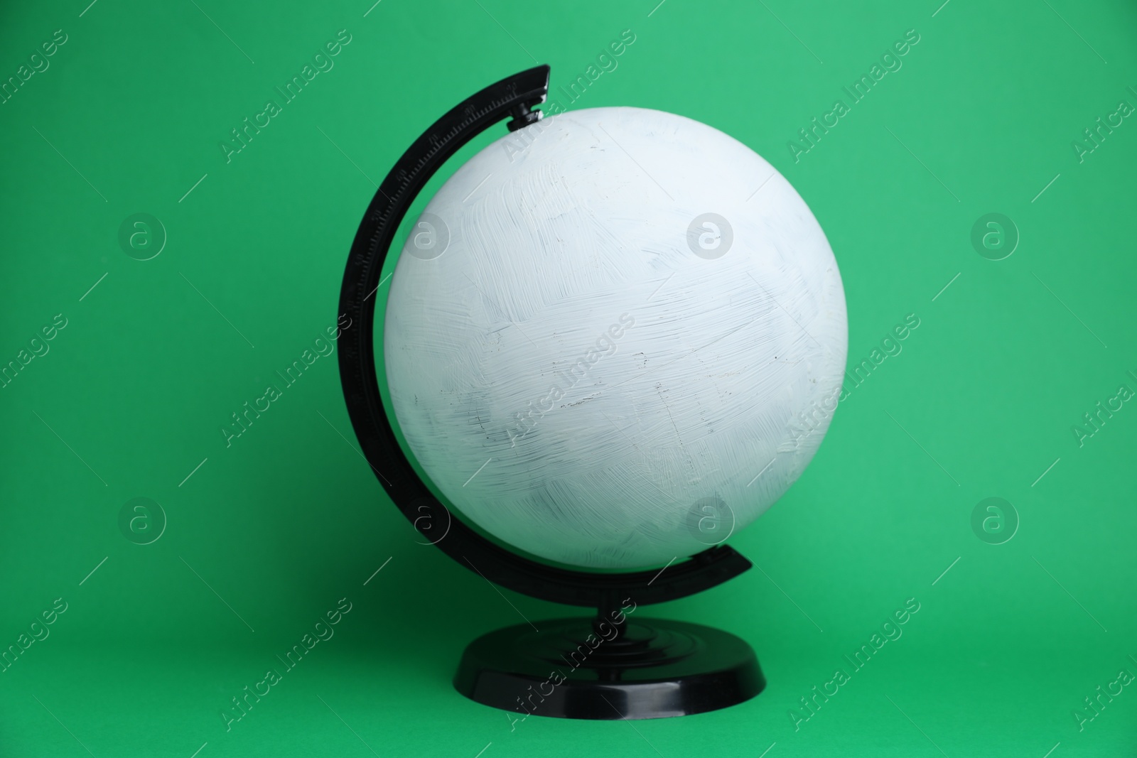 One white plastic model globe on green background Photo of One white plastic model globe on green background