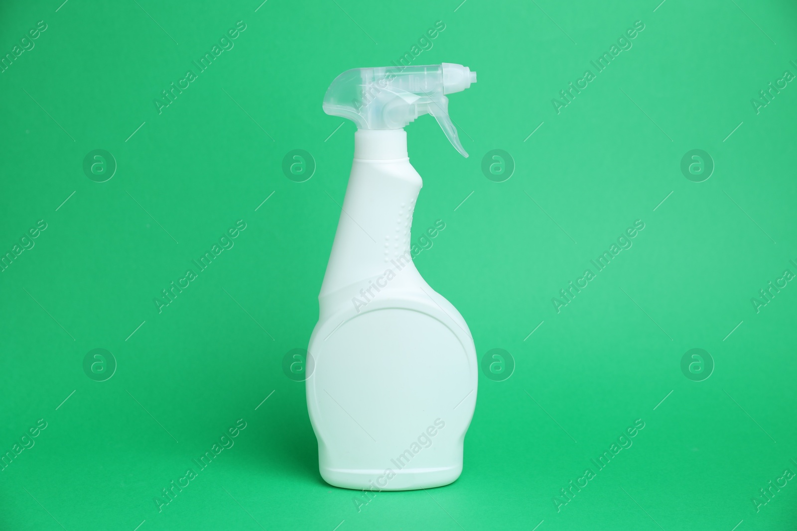 White spray bottle of cleaning product on green background Photo of White spray bottle of cleaning product on green background