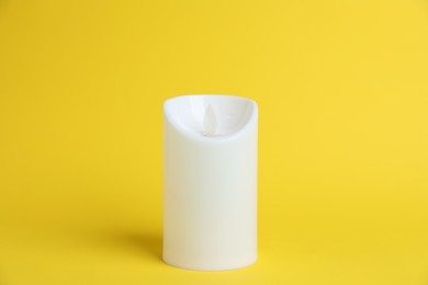 Photo of Decorative flameless LED candle on yellow background
