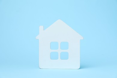 Photo of One white house model on light blue background