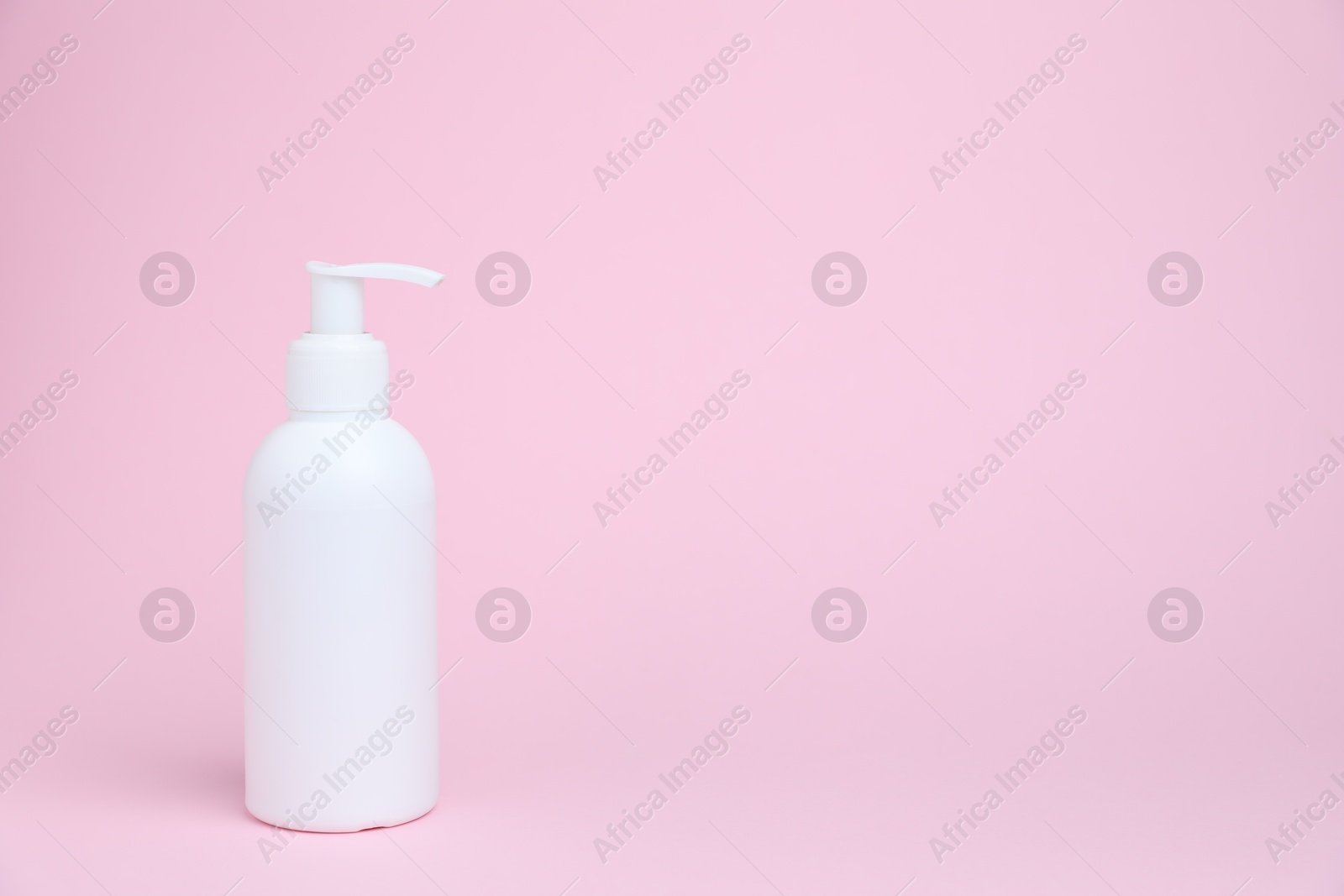 One white bottle of cosmetic product on pink background, space for text Photo of One white bottle of cosmetic product on pink background, space for text