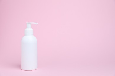 Photo of One white bottle of cosmetic product on pink background, space for text