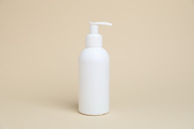 Photo of One white bottle of cosmetic product on beige background