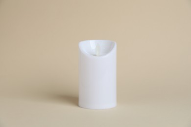 Photo of Decorative flameless LED candle on beige background