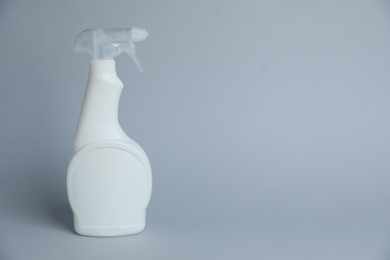 Photo of White spray bottle of cleaning product on light grey background, space for text