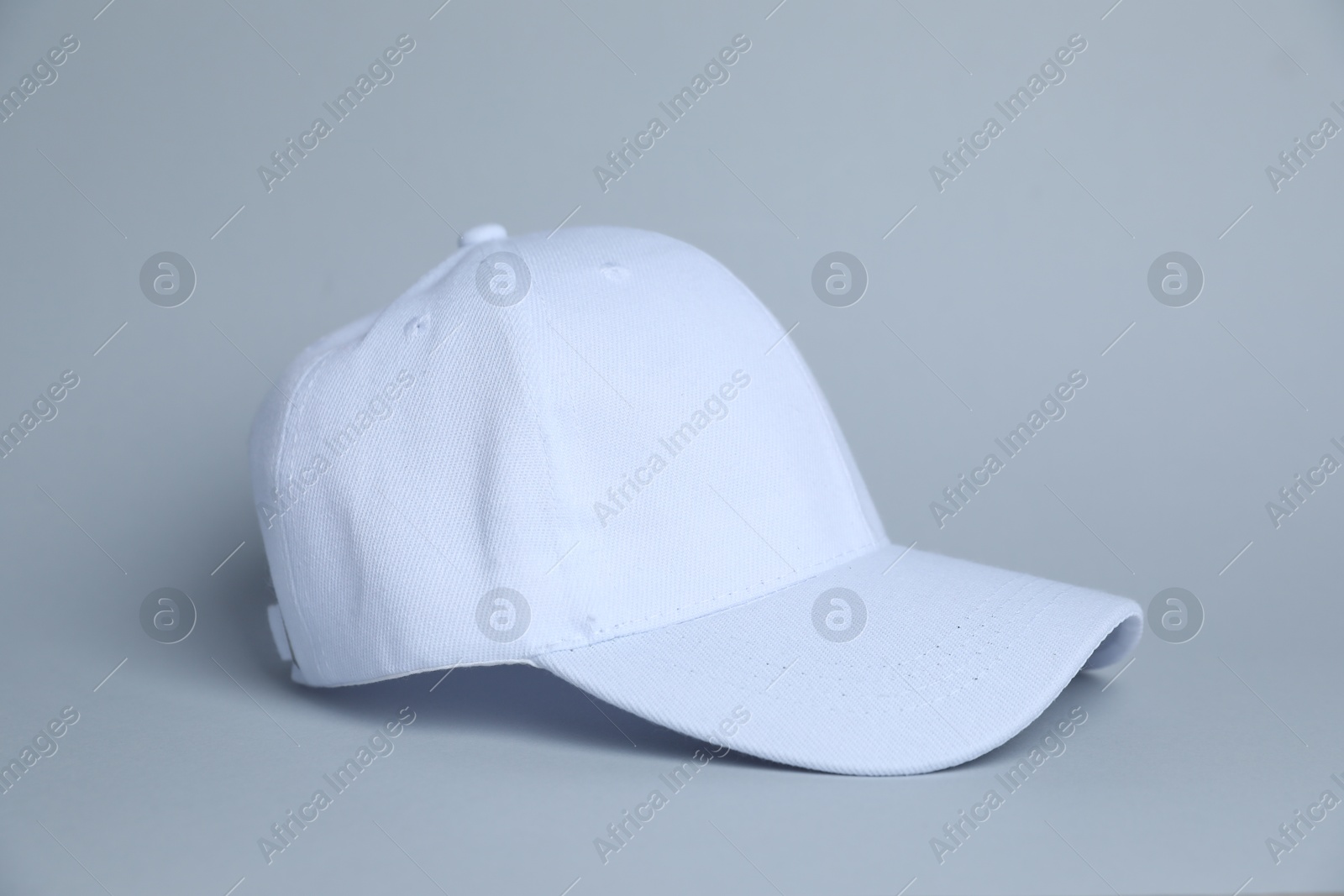 One white baseball cap on light grey background Photo of One white baseball cap on light grey background