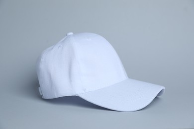 Photo of One white baseball cap on light grey background