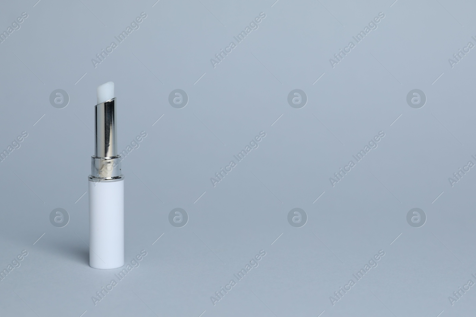 One white lipstick on light grey background, space for text Photo of One white lipstick on light grey background, space for text