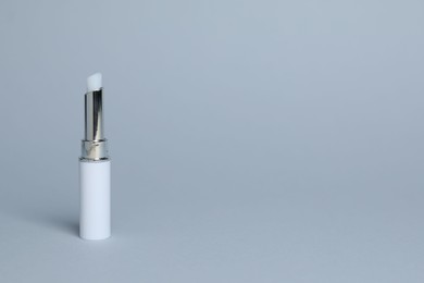Photo of One white lipstick on light grey background, space for text