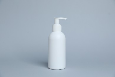 Photo of One white bottle of cosmetic product on light grey background