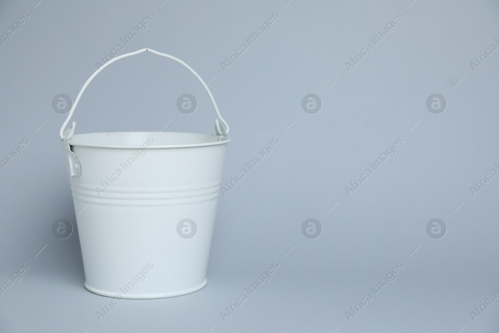 One white bucket on light grey background, space for text Photo of One white bucket on light grey background, space for text