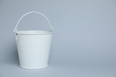 Photo of One white bucket on light grey background, space for text