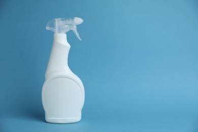 Photo of White spray bottle of cleaning product on light blue background, space for text