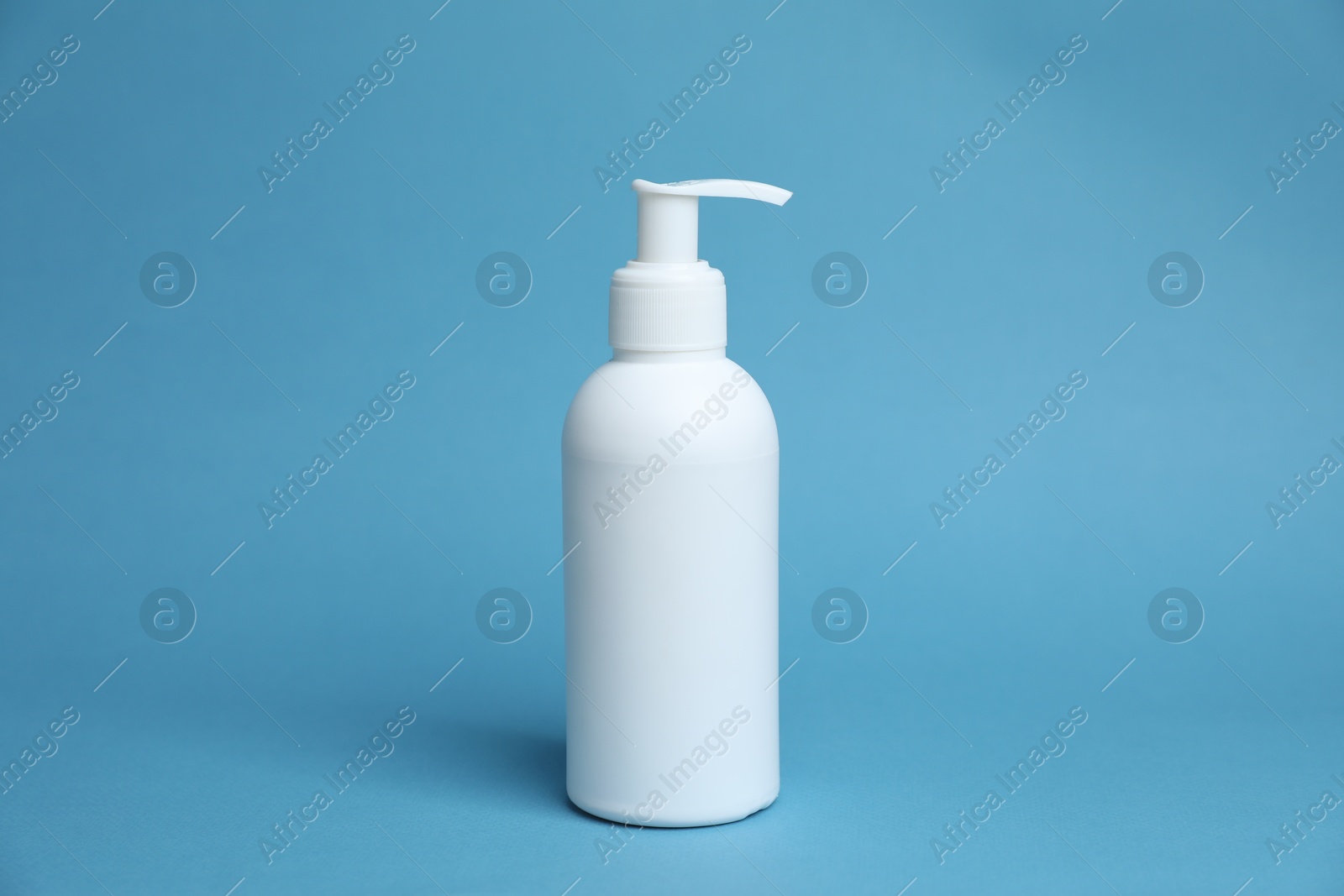 One white bottle of cosmetic product on light blue background Photo of One white bottle of cosmetic product on light blue background