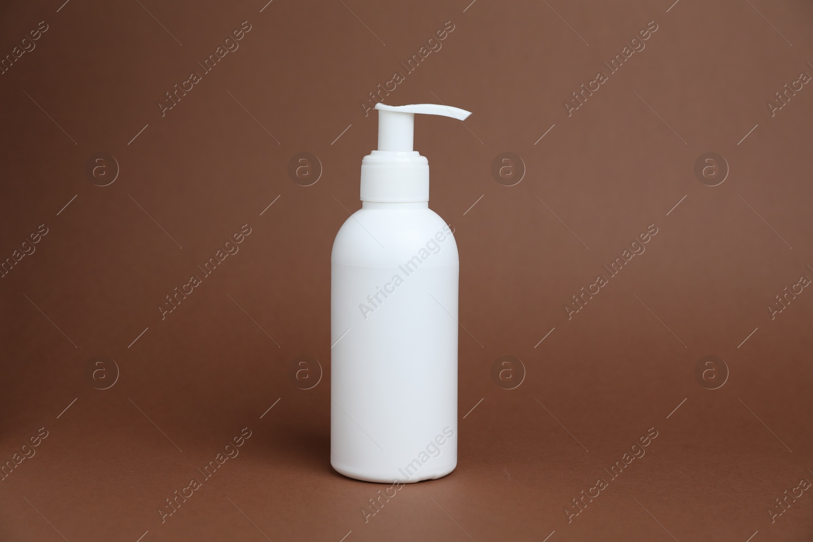 Photo of One white bottle of cosmetic product on brown background