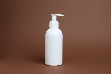 Photo of One white bottle of cosmetic product on brown background