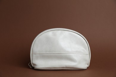 Photo of One white cosmetic bag on brown background