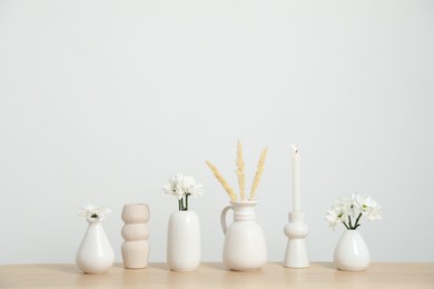 Photo of Different decor on wooden table near white wall indoors