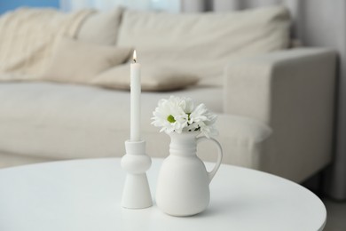 Photo of Beautiful chrysanthemum flowers in vase and burning candle on white table indoors
