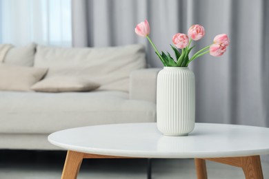 Photo of Beautiful tulip flowers in vase on white table indoors, space for text