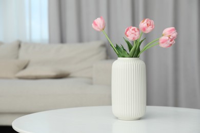 Photo of Beautiful tulip flowers in vase on white table indoors, space for text