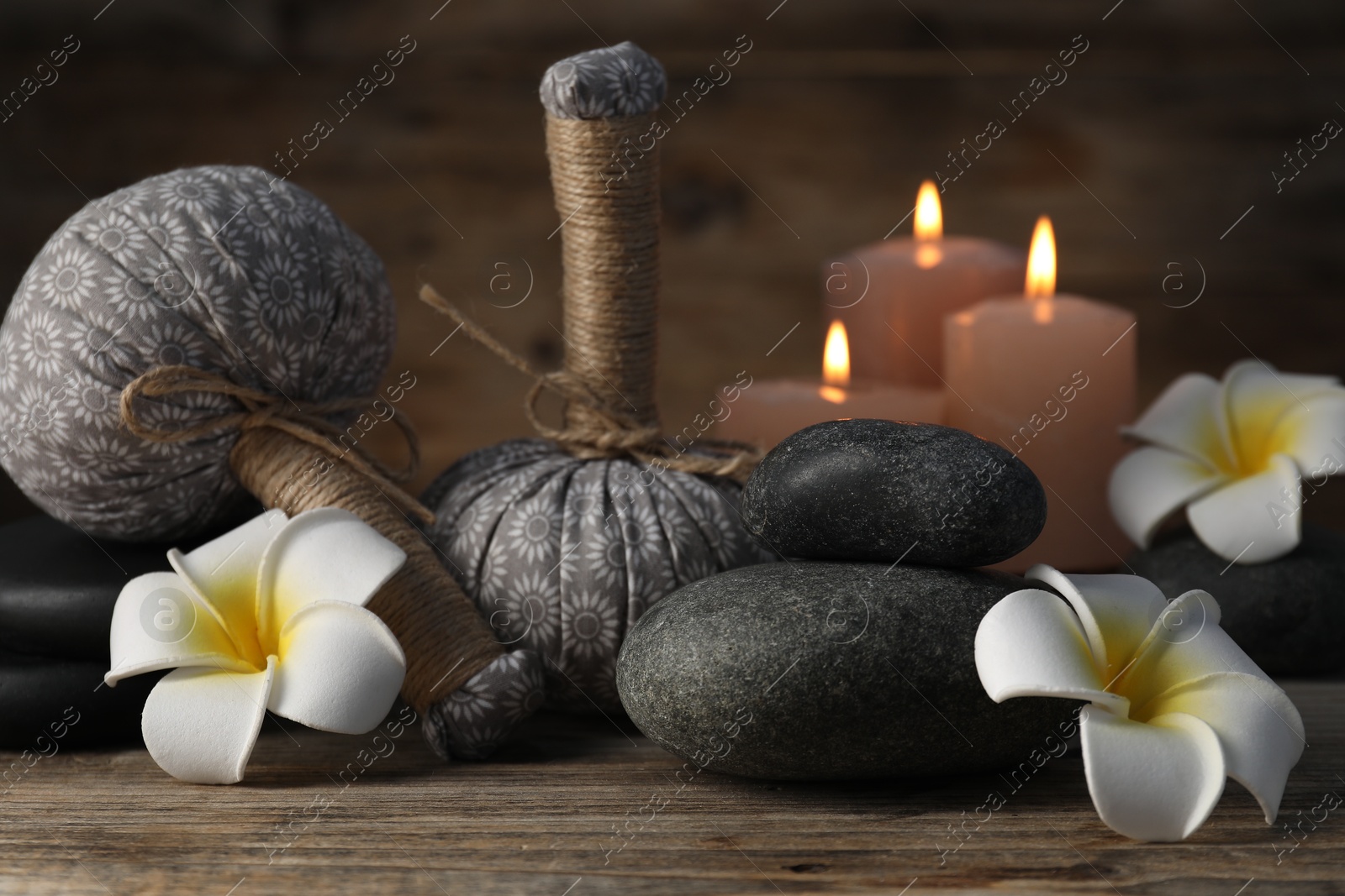 Composition with herbal bags and spa stones on wooden table, closeup Photo of Composition with herbal bags and spa stones on wooden table, closeup