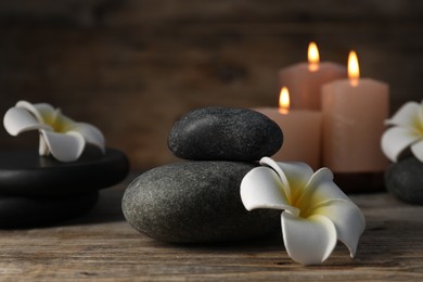 Photo of Composition with spa stones on wooden table, closeup