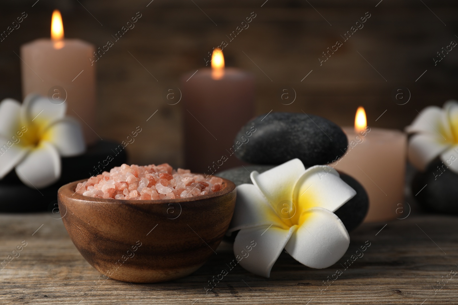 Composition with sea salt and spa stones on wooden table, closeup Photo of Composition with sea salt and spa stones on wooden table, closeup