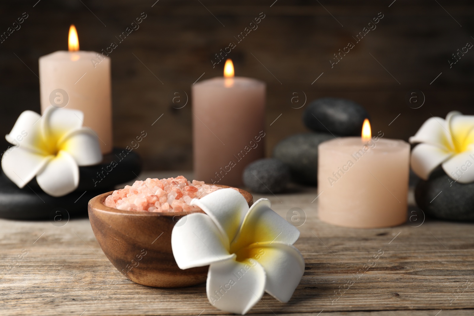 Composition with sea salt and spa stones on wooden table, closeup Photo of Composition with sea salt and spa stones on wooden table, closeup