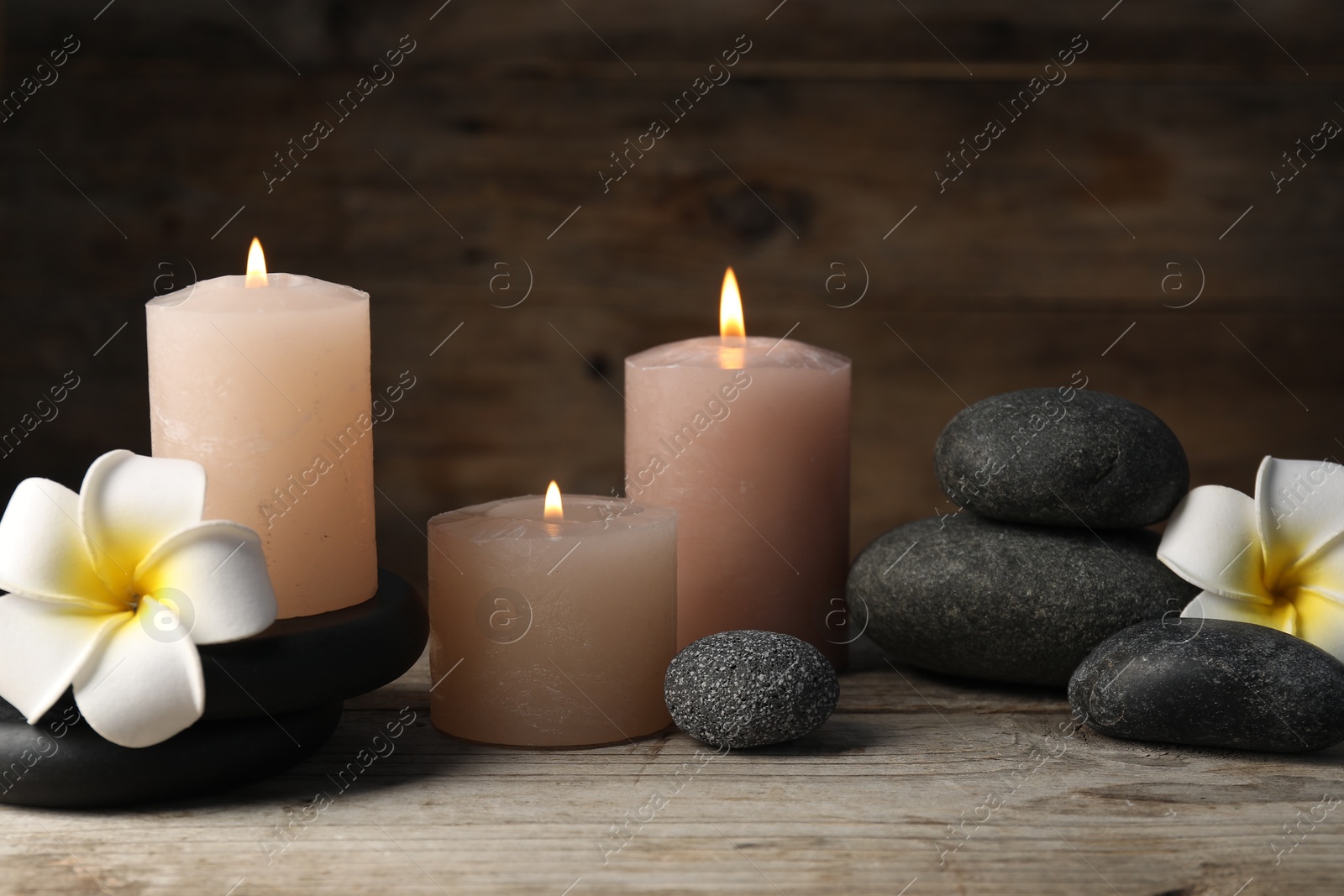 Photo of Composition with spa stones on wooden table, closeup