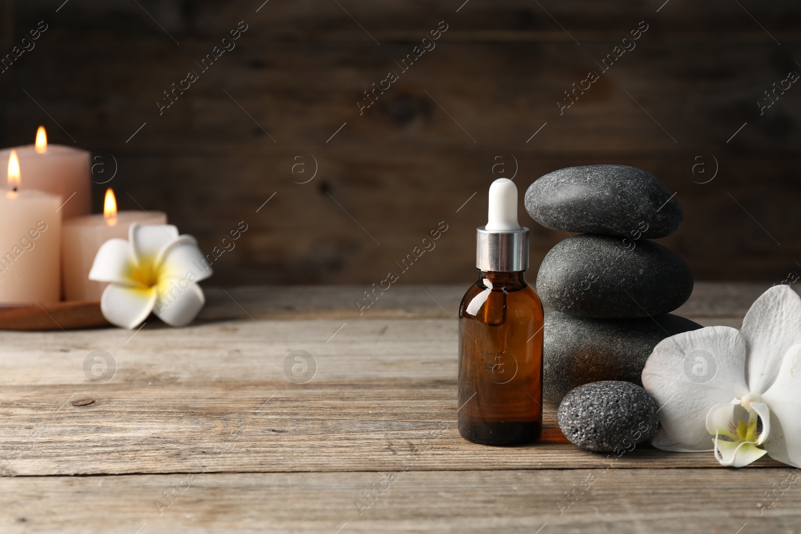 Composition with cosmetic product and spa stones on wooden table, closeup. Space for text Photo of Composition with cosmetic product and spa stones on wooden table, closeup. Space for text